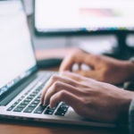 Hands Typing on Laptop Keyboard