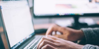 Hands Typing on Laptop Keyboard